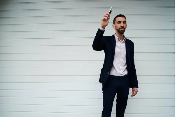 Millennial businessman dressed in smart casual clothes waving at publicity area with copy space for text advertising