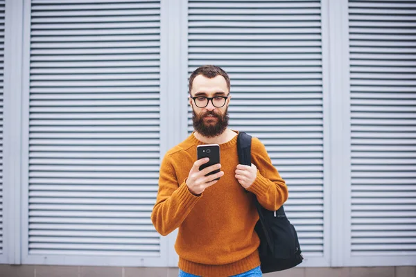 Serious Bearded Male Casual Outfit Backpack Looking Screen Smartphone While — Foto Stock