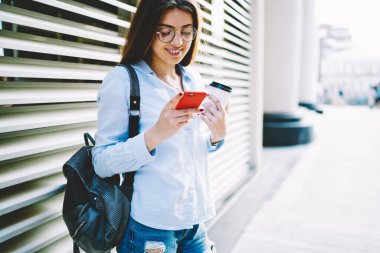 Optik göz giysisi okuyan mutlu beyaz kız öğrenci akıllı telefondaki kablosuz bağlantıyı kullanarak kısa mesaj aldı