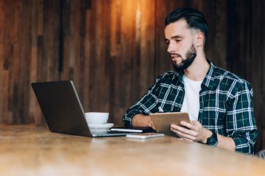 Beyaz tenli erkek öğrenci, günlük kıyafetlerini giyip bilgisayar aracılığıyla e-öğrenim ve öğrenim için Webinar videoları izliyor.