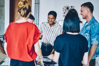 Gülümseyen, çoklu etnik çeşitliliğe sahip zeki insanlardan oluşan bir grup masanın üzerindeki belgeleri kontrol edip analiz etmeyi tartışıyorlar.