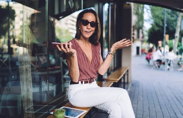 Optimistisch Volwassen Dame Stijlvolle Kleding Gesticuleren Spreken Terwijl Zitten Bank — Stockfoto