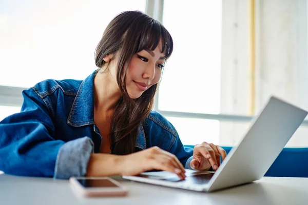 在社交媒体上使用笔记本电脑和4G互联网连接搜索网页的年轻亚洲女性 — 图库照片