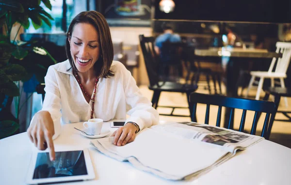  Sabah saatlerinde dijital tablet kullanan neşeli blogcu yeni gazete ile çevrimiçi ağ oluşturma