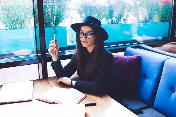 Kafeteryada elinde defterle oturup ödev yaparken, gözlüklü, sıradan giyinmiş, dalgın bir kız öğrenci gözlerini kaçırıyor.