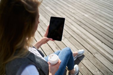 Şehirdeki 4g kablosuz bağlantıyı kullanarak modern dokunmatik ped aygıtı üzerinde web sayfasına göz atan tanınamayan kadın blogger