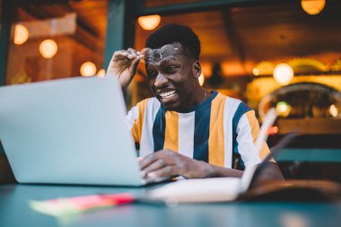 Şok olmuş erkek öğrenci internette netbook teknolojisi üzerinde çalışırken, ders çalışması için webinar 'ı izlerken şaşkın hissediyor.