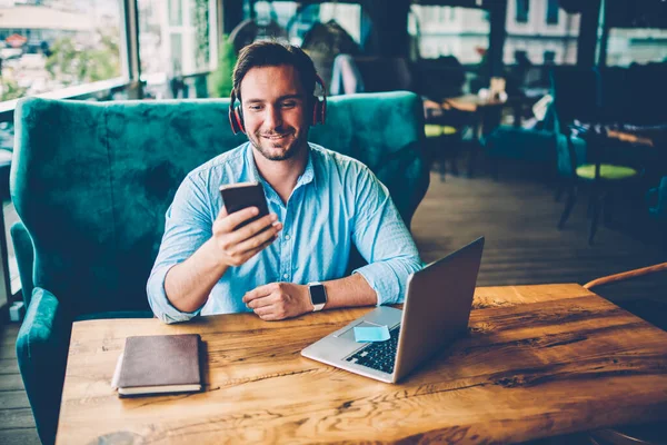 Sorrindo Designer Masculino Fones Ouvido Leitura Notificação Telefone Digital Sentado — Fotografia de Stock