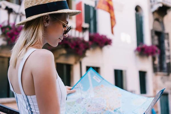 ヴィンテージハウスの外に立つコンテンツの女性の側面図とイタリアのヴェネツィアでの時間を過ごしながら紙の地図を調べる — ストック写真