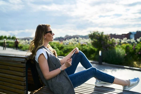 Kafkas kadın turist günlük giysiler içinde seyahat tatillerinde dinleniyor boş zamanlarında bankta hayal kuruyor.