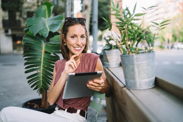 Optimistic Middle Age Casual Female Sunglasses Touching Chin Using Tablet — Stock Photo, Image