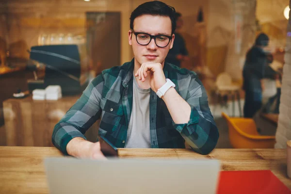 Genom Glas Fokuserade Manliga Vidröra Haka Sitter Med Mobiltelefon Tittar — Stockfoto