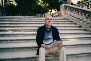 Modern dijital teknolojiye sahip düşünceli bir son sınıf öğrencisi açık hava seyahatleri için rezervasyon yaptırıyor.