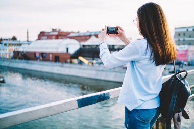 Bin yıllık kadın turistin, mobil kamerasını nehre odaklayıp akıllı telefon aygıtında resim çekmesinin arka planı.
