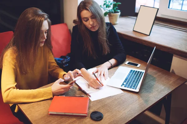 Desde Arriba Mujeres Freelancers Enfocadas Sentadas Mesa Tomando Notas Papel —  Fotos de Stock