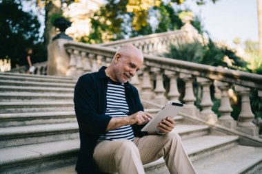 Mutlu Kafkasyalı blogcu 60 yaşında. Tek başına seyahat ederken 4G kablosuz bağlantıya bağlı çevrimiçi ağ için modern dokunmatik ped kullanıyor.