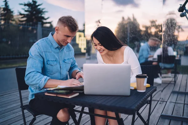 Joven Pareja Positiva Ropa Casual Sentada Mesa Con Portátil Discutiendo — Foto de Stock