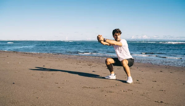 Güneşli Bir Günde Kumlu Sahilde Dikilirken Spor Giyerek Bacaklarını Esneterek — Stok fotoğraf