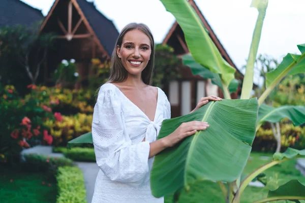 Happy Female Traveler Toothy Smile Resting Tropical Plants Looking Camera — Stockfoto