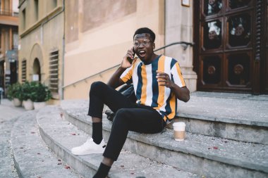 Şok olmuş klasik göz giysisi içindeki erkek turist, şehirdeki uluslararası akıllı telefon görüşmeleri sırasında aldığı haberler karşısında hayrete düştü.