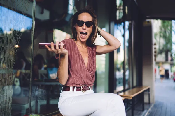 정신적으로 유행하는 선글라스를 스마트폰을 네트워크의 소식으로 기쁨에 — 스톡 사진