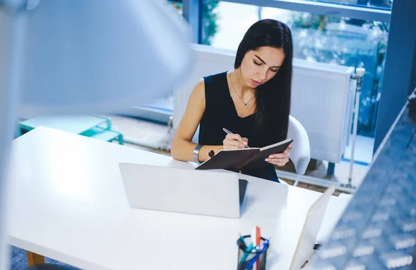 Young Female Worker Sitting Table Laptop Taking Notes Notepad While — Stock Photo, Image