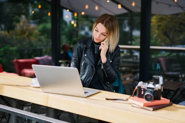 Jeune Femme Assise Cafétéria Tout Parlant Sur Smartphone Utilisant Ordinateur — Photo