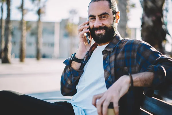 Turkish hipster guy looking at camera while calling to family discussing solo travel and vacations