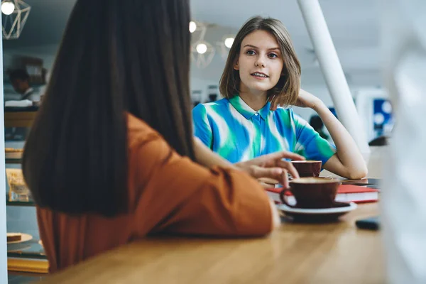 Young Female Friends Sitting Wooden Table Cafeteria Chatting Each Other — Foto Stock