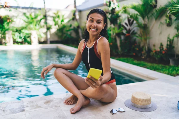 Smiling Ethnic Woman Swimwear Sitting Poolside Crossed Legs Looking Camera —  Fotos de Stock