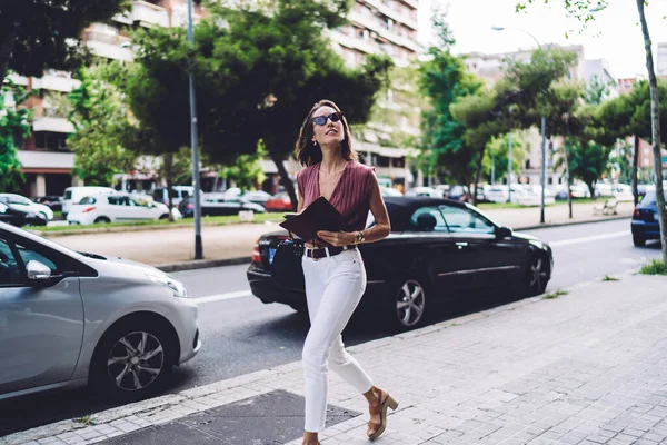 サングラスをかけ 都会の中で自由な時間に歩くことを楽しむスタイリッシュな服装の豊かなビジネス女性 — ストック写真