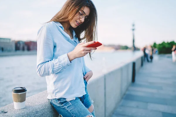 千禧年妇女阅读收到的关于现代智能手机装置在路堤上邮寄的通知 — 图库照片