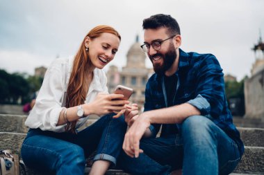 Mutlu Kafkasyalı hippi erkekler birlikte iyi yolculuklar ve en iyi arkadaşlarla akıllı telefon mesajları.