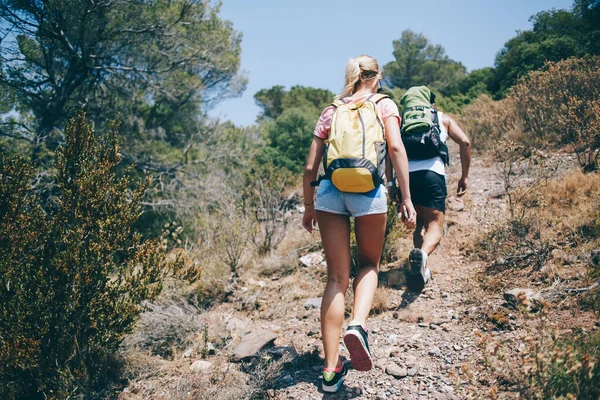 在暑假期间 穿着休闲装背着背包的情侣们一起走在山穷水尽的小径上的背影 — 图库照片