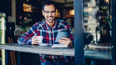 Moda gözlüklü komik hippi 30 'lu yaşların portresi. Kafenin içinde boş zamanlarında kameraya gülümseyen gözler için.