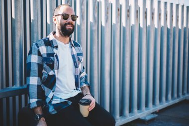 Şehirdeki güneşli bir günde, sokak kentsel ortamında el ele dinlenmek üzere hazır kahve getiren Orta Doğulu erkek turist.