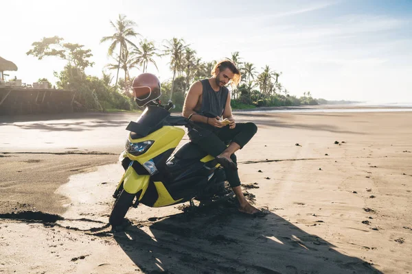 Full Length Brutal Male Biker Sitting Motorcycle Messaging Smartphone While — Zdjęcie stockowe