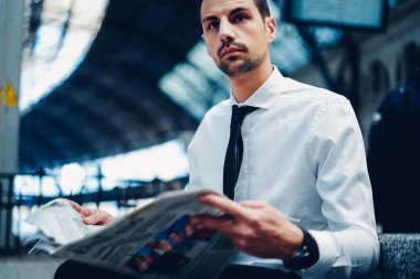 Beyaz resmi gömlekli ve siyah kravatlı beyaz iş adamı sabah ve günlük rutin olarak tren yolunu bekliyor.