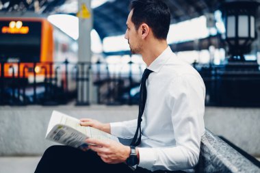 Beyaz resmi gömlekli ve siyah kravatlı beyaz iş adamı sabah ve günlük rutin olarak tren yolunu bekliyor.