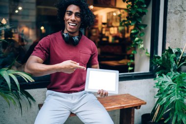  Komik hippi adam elinde reklam amaçlı seyahat metinleri için fotokopi aletiyle dokunmatik ped tutuyor.