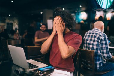 Kıvırcık erkek programcı uzaktan çalışma ve web projeksiyonunda utanç duyuyor.