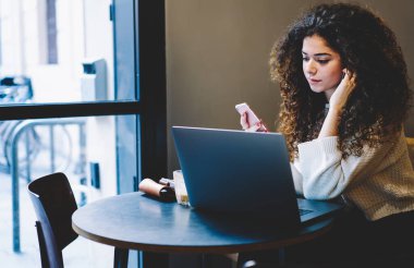 Milenyum kadını, kafeteryadaki internet bağlantısını kullanarak dizüstü bilgisayardan web videosu izliyor.