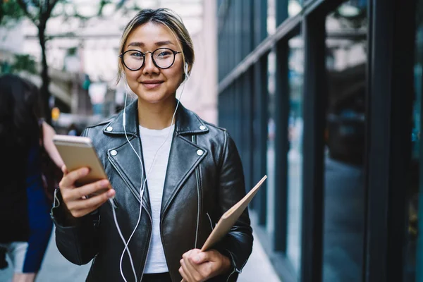 Mutlu milenyum blogcusunun yarım boy portresi eğitim eskiz defteriyle kameraya gülümserken pozitif müzik podcast 'i dinliyor.