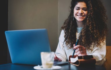  Neşeli Kafkasyalı öğrenci eğitim için netbook teknolojisini kullanıyor ve kahve dükkanında öğreniyor.