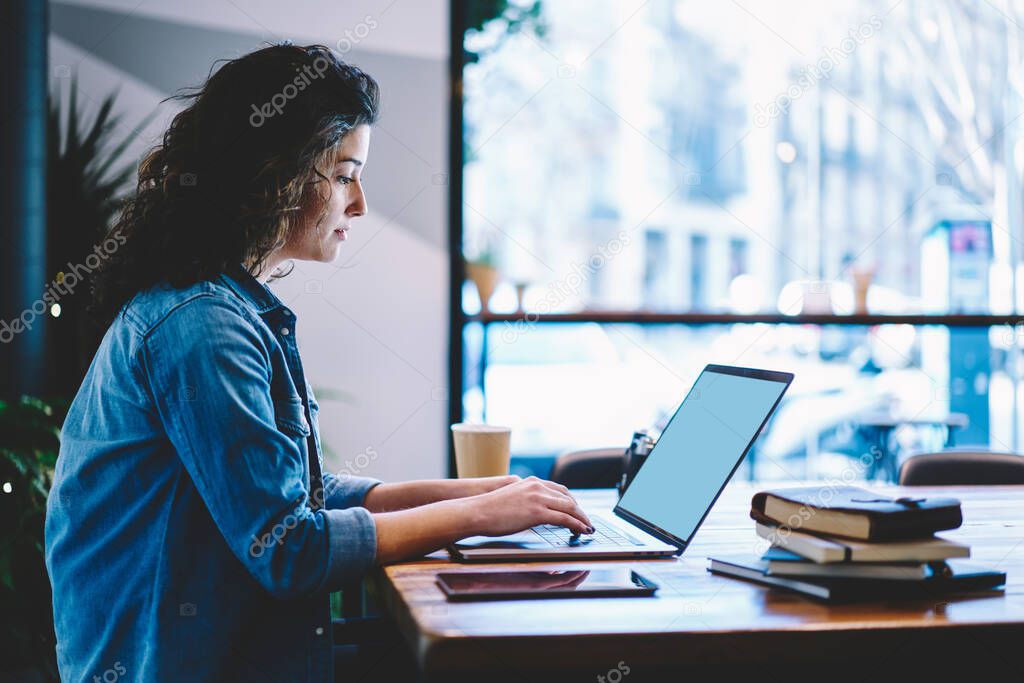 Caucasian female student preparing to university exams while e learning on netbook in coworking space