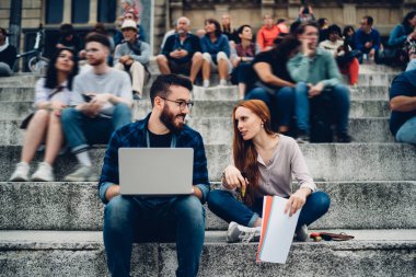 Uzaklık işbirliğini tartışan bilgilendirme amaçlı araştırmalar için belge ve laptop teknolojisine sahip kadın ve erkek serbest çalışanlar. 