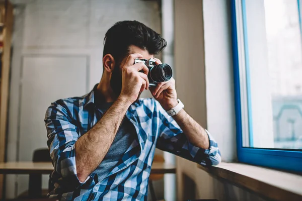 食堂の窓 室内のレトロな時代遅れの科学技術経由で画像を撮る若いプロの男性写真家の近くビンテージ カメラを使用して画像を作る才能のある創造的な白人ヒップ男 — ストック写真