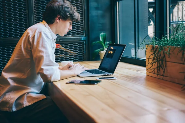 Seriöser Mann Hemd Surft Mit Touchpad Laptop Während Distanziert Holztisch — Stockfoto