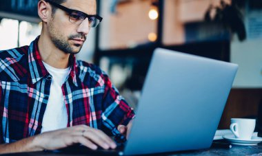 Web programlaması yapmak için birlikte çalışan internete bağlanan optik gözlüklerdeki yetenekli erkek yazılım geliştirici