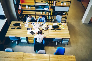 Resmi olarak giyinmiş siyah bir erkek ve iş arkadaşlarıyla el paylaşım projesinin kağıt işlerinde kullandığı gözlüklü bir gözlük.